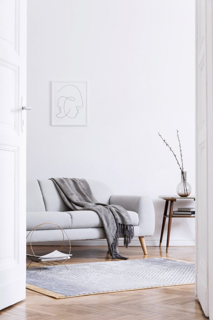 Minimalist Scandinavian Living Room with Grey Sofa Line Art and Herringbone Hardwood Floors.jpg