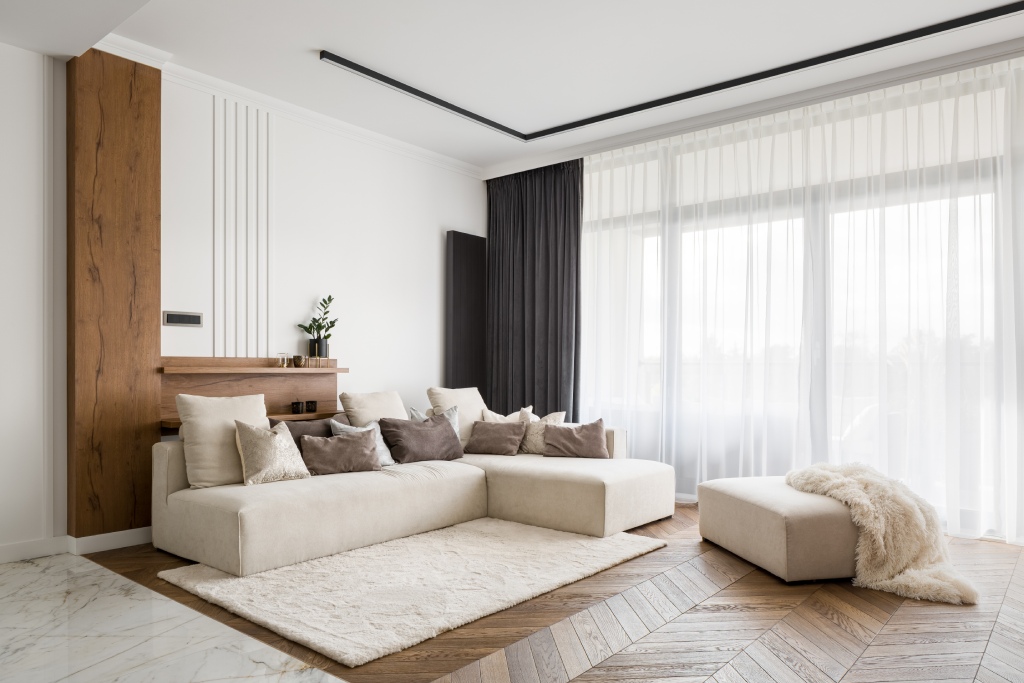 Modern Minimalist Living Room with Chevron Hardwood Floors Cream Sectional Sofa and Wood Accent Wall.jpg