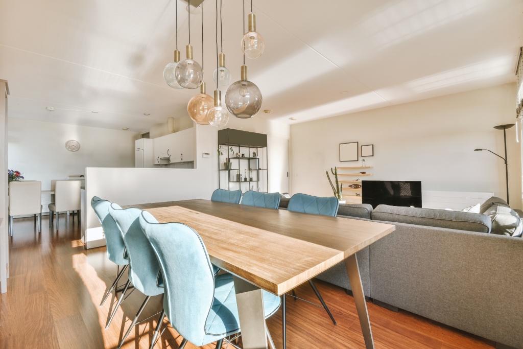 Modern Open Concept Dining and Living Room with Teak Table Blue Velvet Chairs and Glass Globe Chandelier.jpg